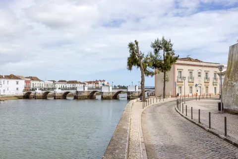 Historic riverside promenade and old bridge in Tavira, a popular retirement town in the Algarve
