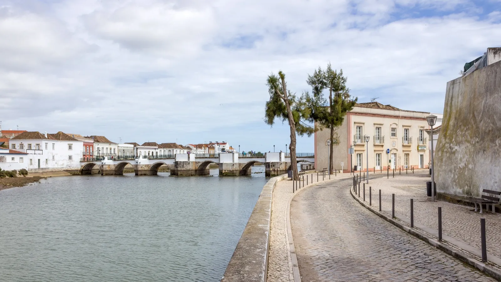Historic riverside promenade and old bridge in Tavira, a popular retirement town in the Algarve