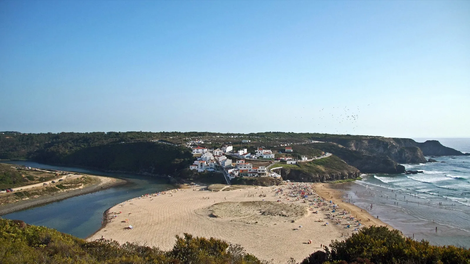 Aerial view of Praia de Odeceixe where a river meets the Atlantic on Portugal's west coast in June