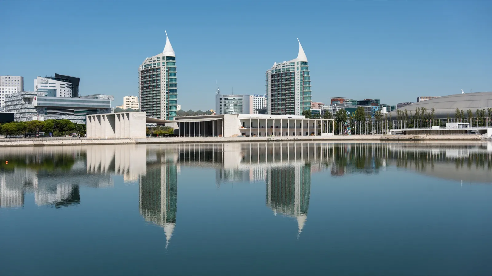 Modern glass towers of Lisbon's Parque das Nacoes business district reflected in water