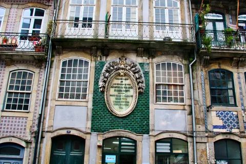 Traditional Portuguese building facade with ceramic azulejo tiles and wrought-iron balconies