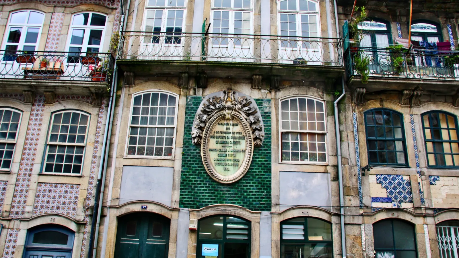 Traditional Portuguese building facade with ceramic azulejo tiles and wrought-iron balconies