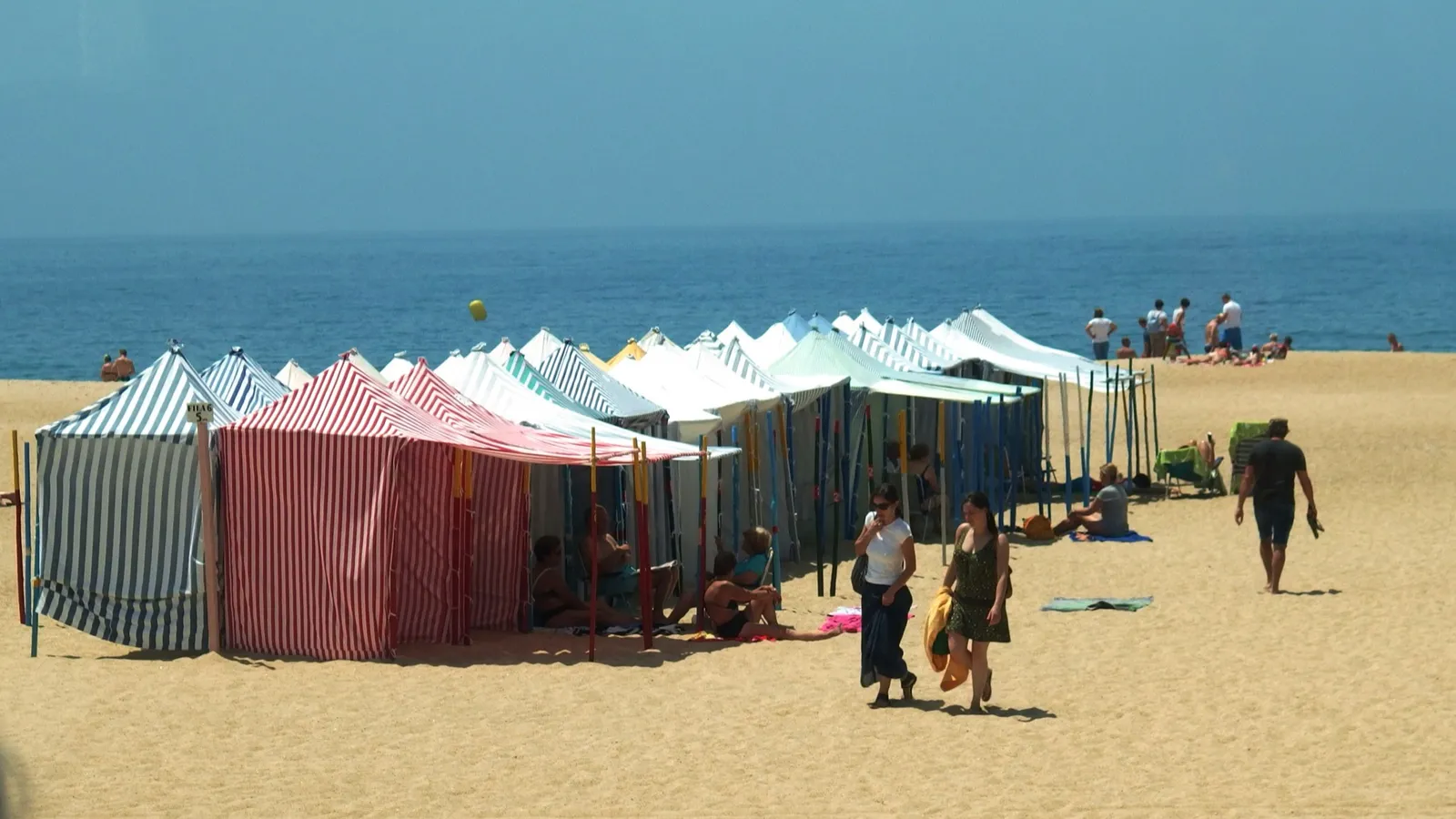 Traditional striped beach tents on a sandy Portuguese beach in summer