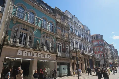 Tiled 19th-century façades along Rua de Santa Catarina in central Porto, with shoppers on the calçada pavement
