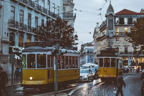 Lisbon yellow trams on cobblestone street — moving to Portugal from the USA