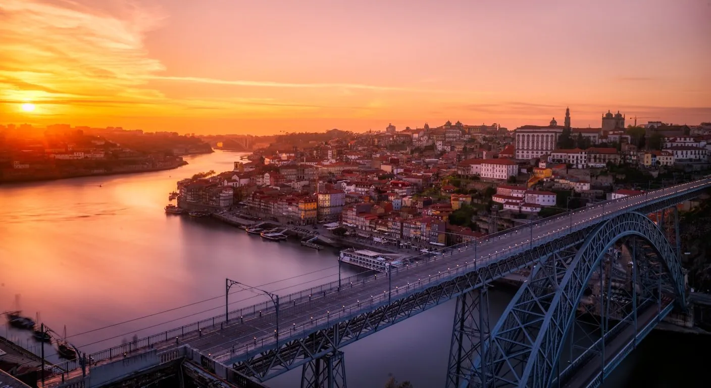 Porto e a ponte Dom Luís I sobre o Douro ao pôr do sol, ponto de partida de um roteiro de carro pelo norte de Portugal