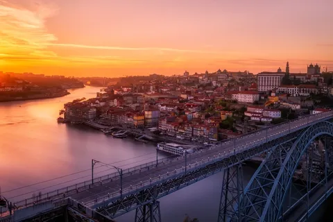 Porto e a ponte Dom Luís I sobre o Douro ao pôr do sol, ponto de partida de um roteiro de carro pelo norte de Portugal