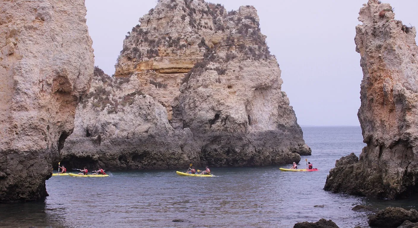Байдарочники серед золотих морських скель Ponta da Piedade біля Lagos в Алгарве, Португалія