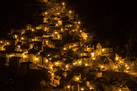 Piódão schist village lit up at night cascading down the hillside — a hidden gem in central Portugal