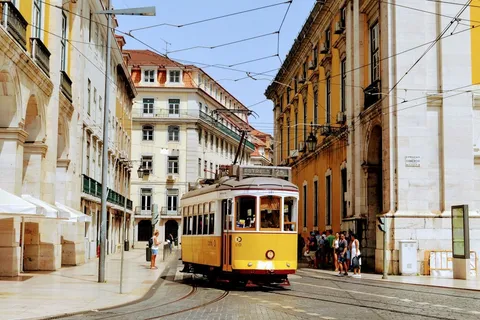 Iconic yellow Tram 28 on a historic Lisbon street, illustrating the cost of living in Lisbon Portugal 2026