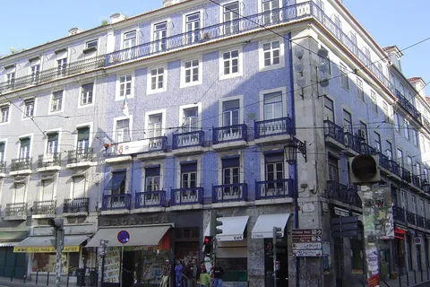 Tiled Lisbon apartment building with iron balconies, renting vs buying in Portugal