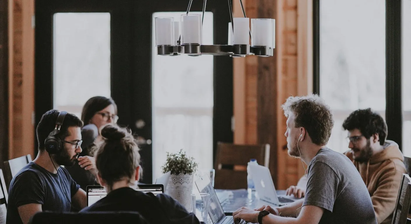 Trabalhadores remotos com portáteis numa mesa partilhada num espaço de coworking em Lisboa