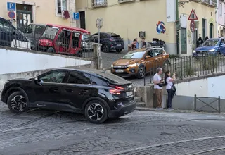 Voitures garées dans une rue pavée étroite de Lisbonne avec des plaques d'immatriculation portugaises, illustration de l'achat d'une voiture au Portugal