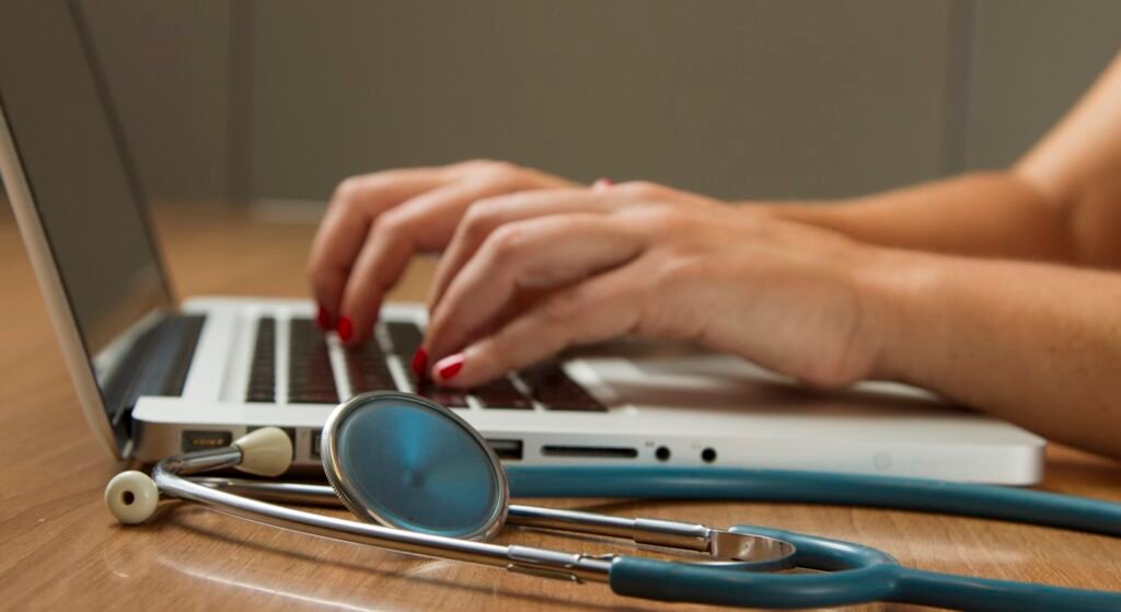 Stethoscope next to a laptop — comparing health insurance for expats in Portugal