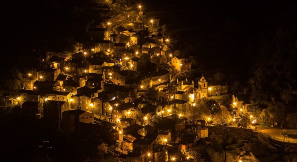 Piódão schist village lit up at night cascading down the hillside — a hidden gem in central Portugal